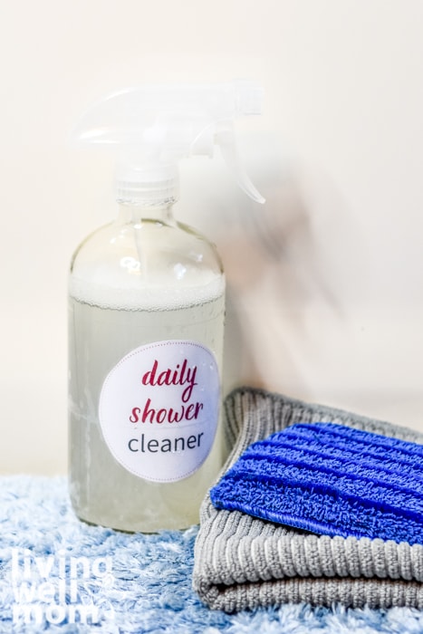 homemade daily shower cleaner in a spray bottle with sponge and cleaning cloth