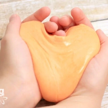 homemade orange silly putty in child's hands
