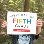 Boy holding a first day of fifth grade printable sign