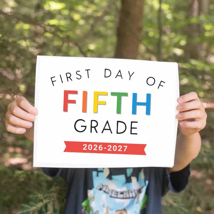 Boy holding a first day of fifth grade printable sign