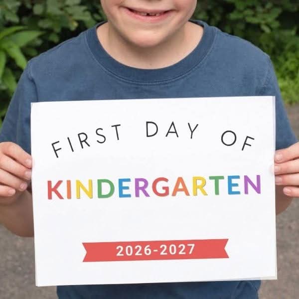 Boy holding a first day of kindergarten sign for 2026