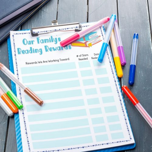 our family's reading rewards printable chart on blue clipboard with markers