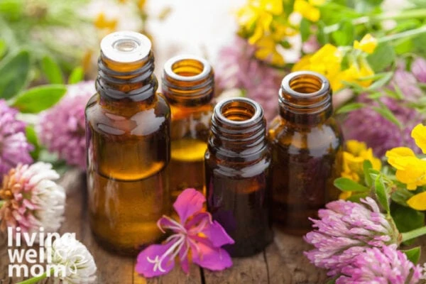 bottles of essential oils for dry skin on a table covered in flowers