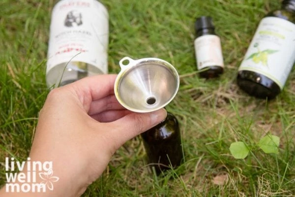 metal funnel with brown metal bottle on grass