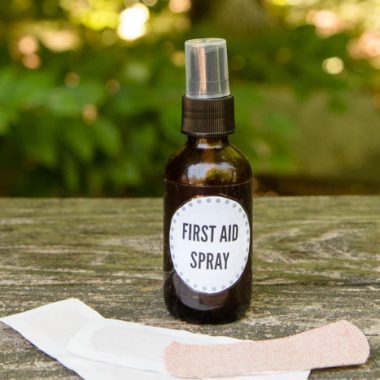 brown glass spray bottle first aid spray with a bandage on wood with woods background