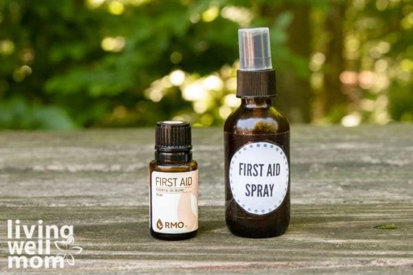 brown glass spray bottle first aid spray and essential oil with a bandage on wood with woods background