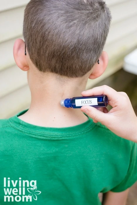rolling an essential oil blend on a child's neck