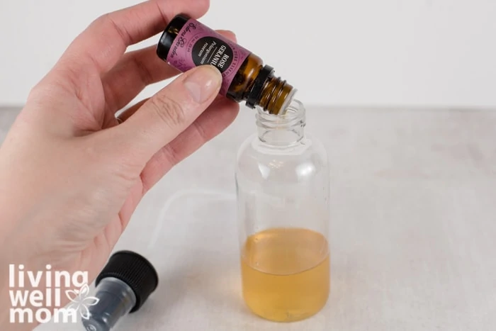 rose geranium essential oil drops into plastic bottle
