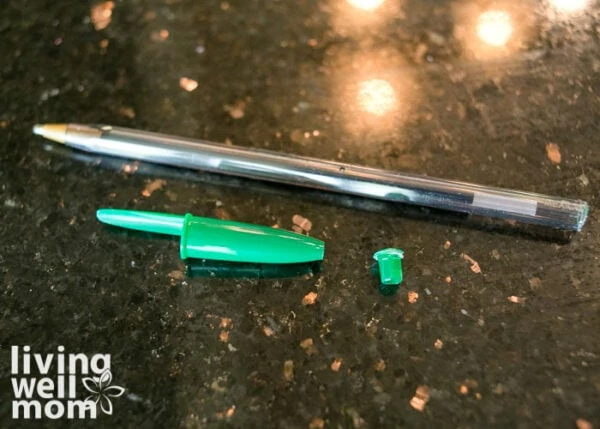 Green ballpoint pen with the caps removed on both ends