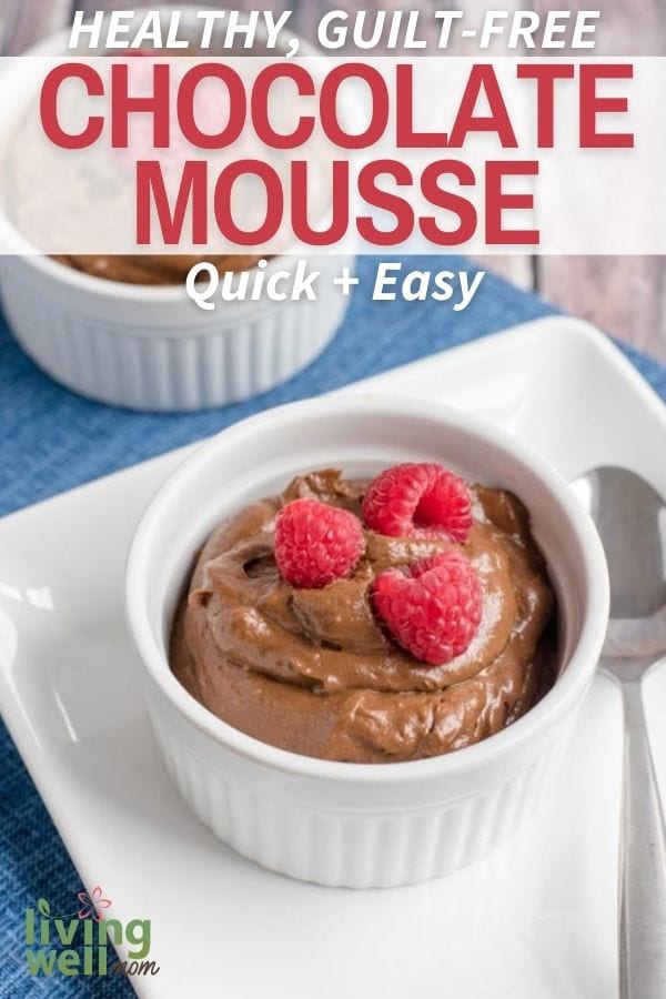 close-up of chocolate mousse in a white bowl with raspberries on a white plate and blue background