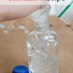 squeezing homemade hand sanitizer into bottle