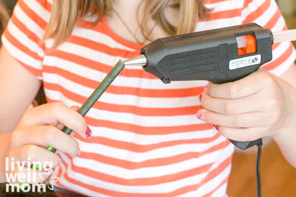 Girl with hot glue gun and a pen