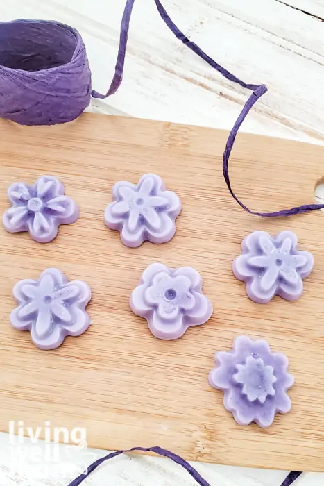 Purple, flower-shaped lotion bars made with essential oils. 