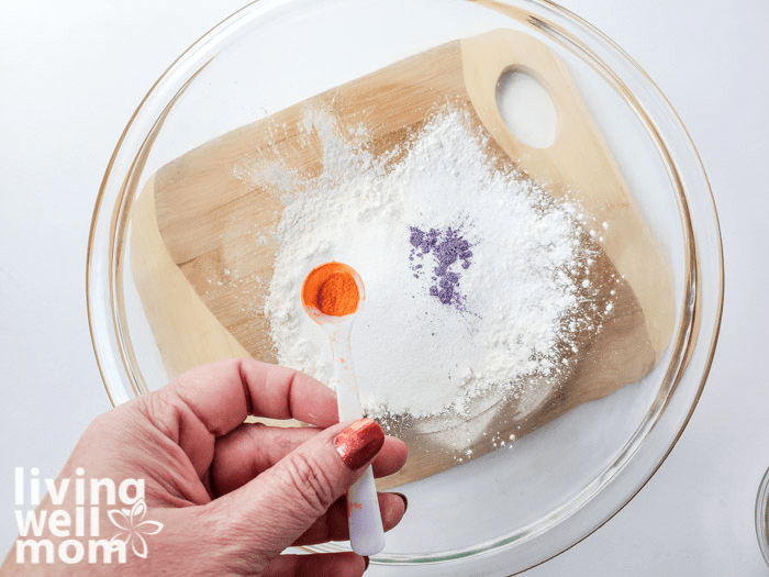 A whisk, mixing together the ingredients for DIY bath salt.