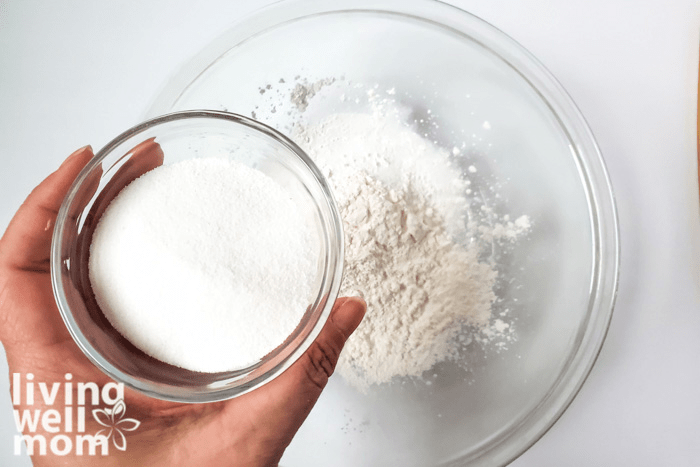A bowl of baking soda above a large bowl of corn starch, citric acid and other ingredients. 