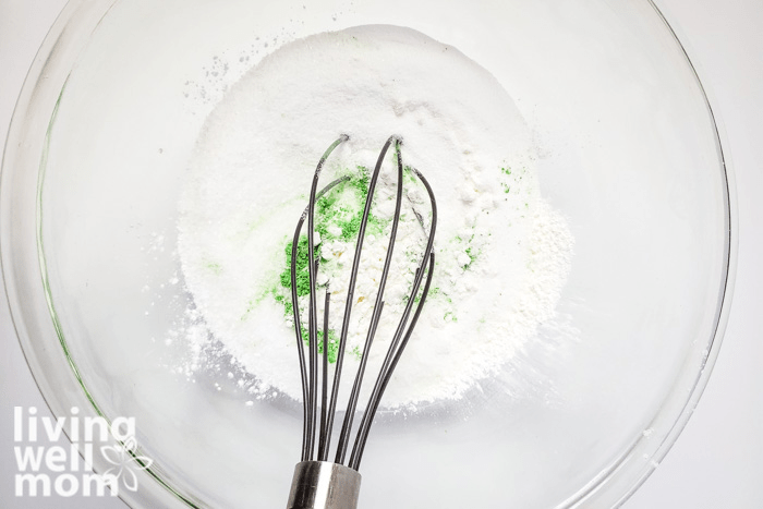 Green mica powder being whisked into homemade fizzy salt mixture. 