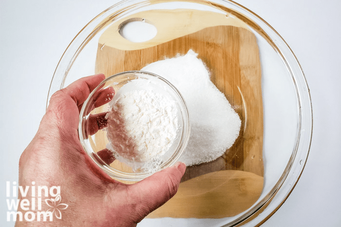 Corn starch being added into dry ingredients for homemade bath bombs. 