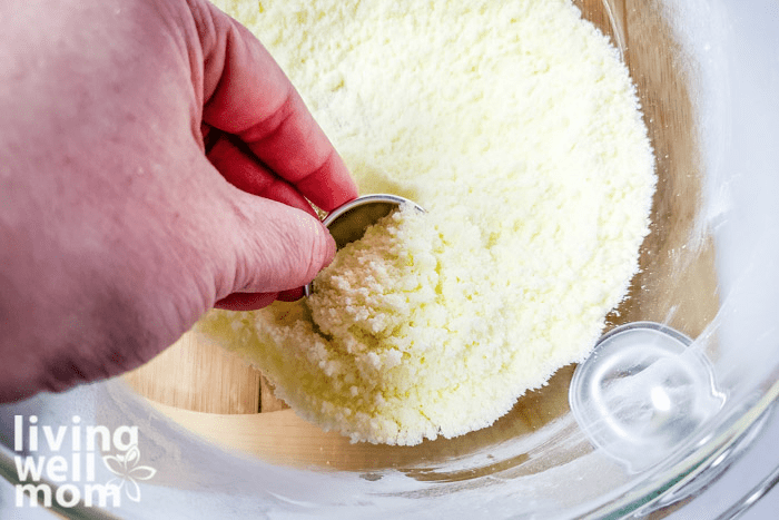 Coconut mixture being scooped into a  mold. 