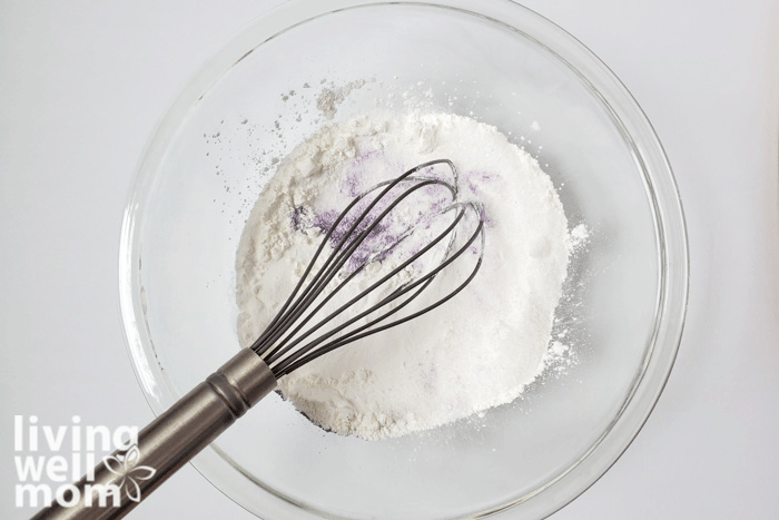 Purple mica powder being whisked into homemade bath bomb mixture. 