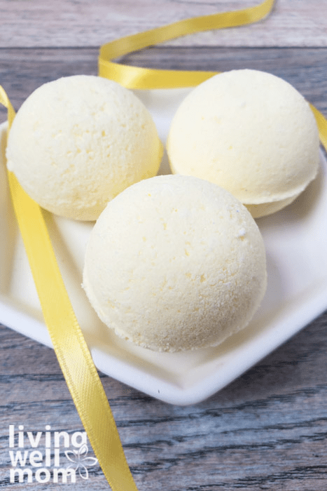 Three yellow DIY bath bombs on a white plate.