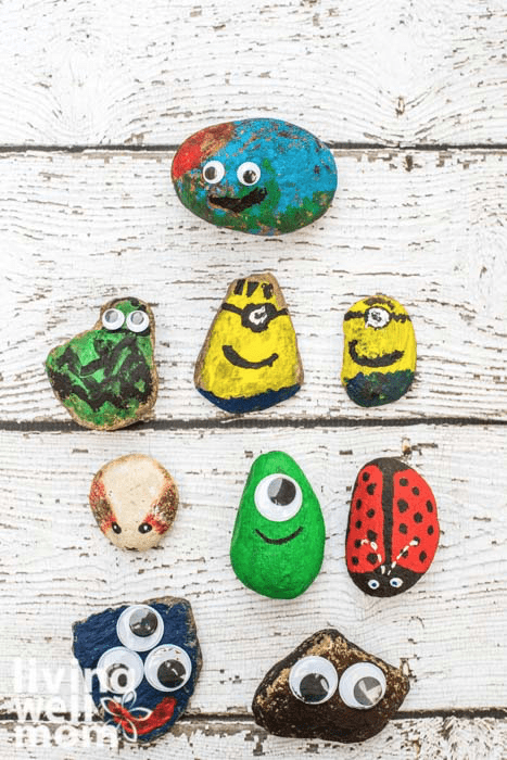 Pet rocks on a wooden table, with painted monsters, animals and minions.