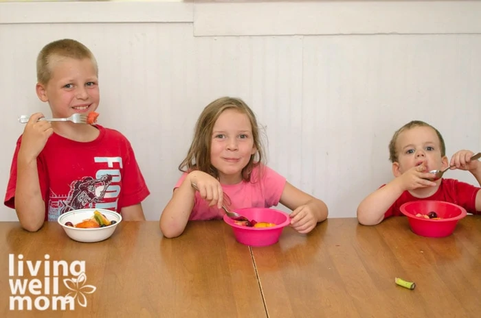 kids eating a simple fruit salad at the dinner table
