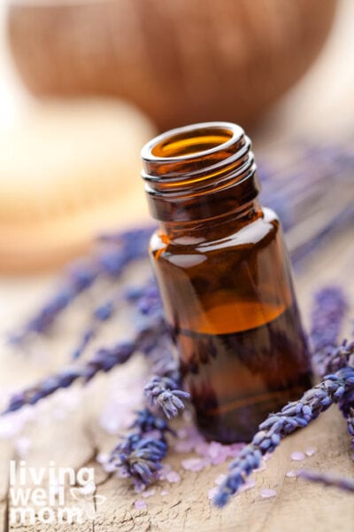 Bottle of lavender essential oil among dried lavender flowers.