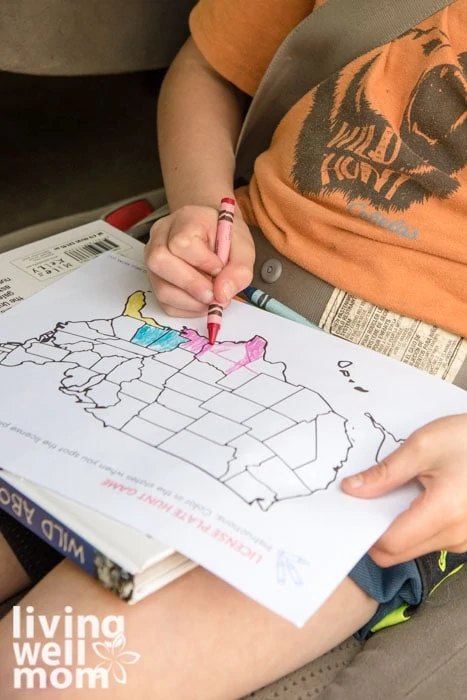Child coloring a US map on a road trip