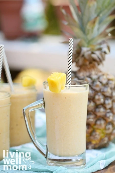 pineapple mango smoothie in glass with straw