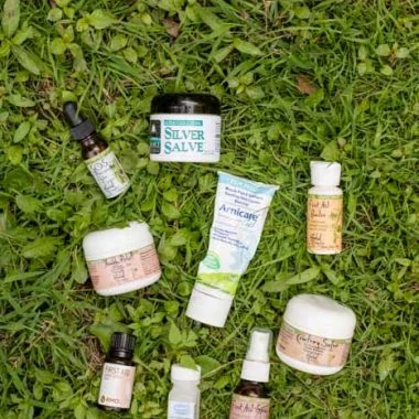 various herbal tubes and bottles for natural medicine kit on green grass