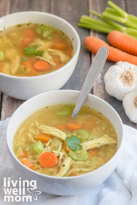 2 bowls of paleo soup with chicken, garlic, carrots, and celery