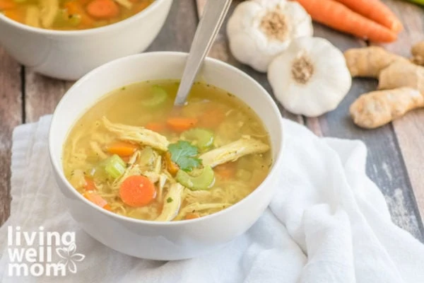 Yummy paleo chicken soup in a white bowl with chunks of chicken and vegetables