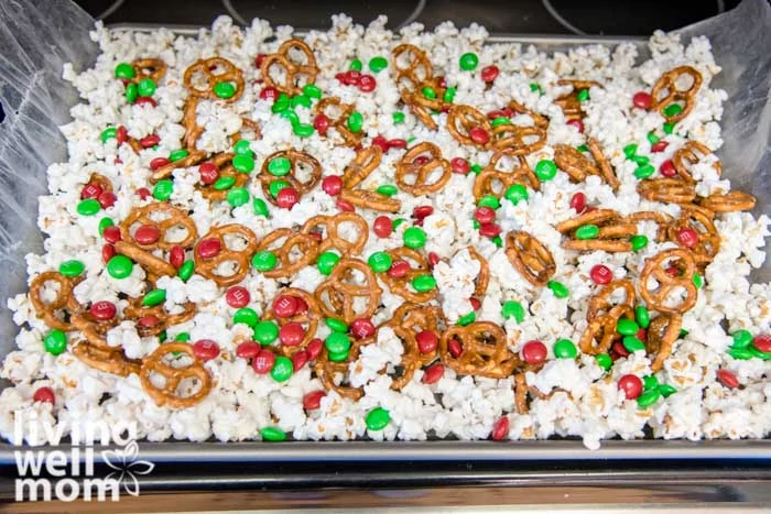 m&ms sprinkled over popcorn and pretzels