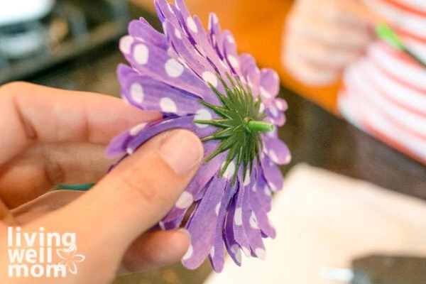 Child holding a faux flower with a small stem