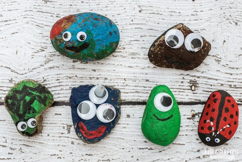 Painted rocks with googley eyes on an outdoor table.