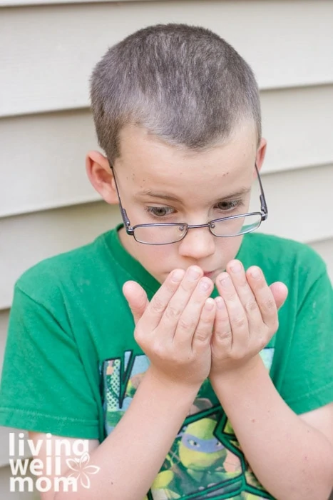 Boy smelling essential oils for focus on his hands