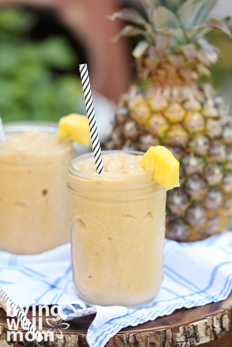 2 smoothies in mason jars with a pineapple in the background