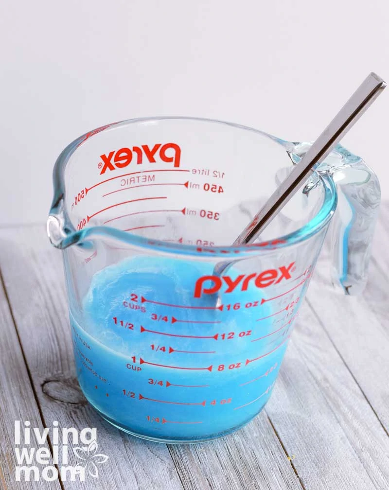 mixing dawn and vinegar together in glass measuring cup
