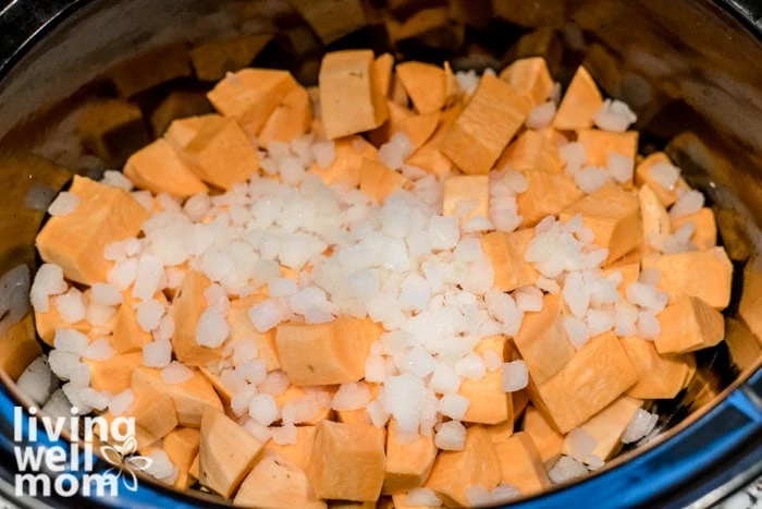 chopped sweet potatoes and onions in a slow cooker for healthy beef stew
