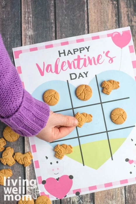 Young girl playing with a tic tack toe valentine using cookies