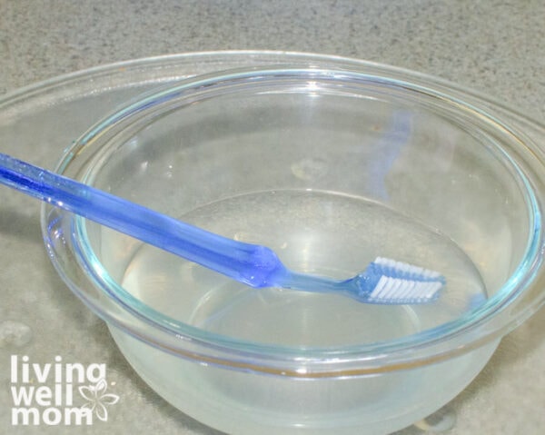 Blue toothbrush in a bowl of microwave cleaner